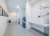 Thumbnail 18 of 34 - A bathroom with white tiled walls and a white bench.