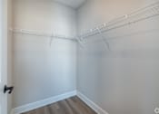 Thumbnail 15 of 34 - A white closet with a door and shelves.