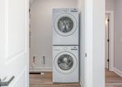 Thumbnail 13 of 34 - A white front loading washing machine in a laundry room.