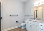 Thumbnail 16 of 34 - A bathroom with a toilet, sink, and towel racks.