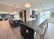 Thumbnail 6 of 61 - A modern kitchen with a long island and bar stools.