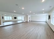 Thumbnail 23 of 61 - A spacious room with wooden flooring and white walls.