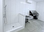 Thumbnail 26 of 61 - A bathroom with a walk-in shower and a table.