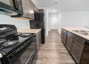 Thumbnail 23 of 26 - a kitchen with dark wood cabinets and stainless steel appliances  at Union at Wiley, Cedar Rapids, IA, 52404