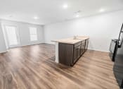 Thumbnail 16 of 26 - a kitchen and living room with hardwood floors and white walls  at Union at Wiley, Cedar Rapids, IA, 52404