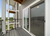 Thumbnail 5 of 21 - A balcony with a glass door and a black railing. at Union at the Loop, Lawrence, KS, 66046