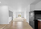 Thumbnail 10 of 21 - A black refrigerator is in a kitchen with white walls and wood floors. at Union at the Loop, Lawrence, KS