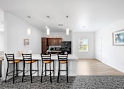 Thumbnail 6 of 21 - A kitchen with a bar area and chairs. at Union at the Loop, Lawrence, KS, 66046