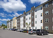 Thumbnail 3 of 13 - A row of modern apartment buildings with cars parked in front.at Union at Crescent, Bloomington, 47404  