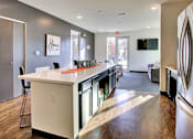 Thumbnail 11 of 13 - A kitchen with a white counter top and a fridge on the right.at Union at Crescent, Bloomington, 47404  