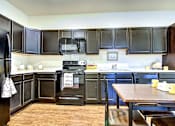 Thumbnail 10 of 13 - A kitchen with black appliances and cabinets.at Union at Crescent, Bloomington, IN 47404  