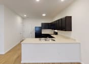 Thumbnail 4 of 18 - A modern kitchen with a white island and wooden floors.at Union at 16th, Indiana, 46222
