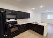 Thumbnail 7 of 18 - A kitchen with black cabinets and a white countertop.at Union at 16th, Indianapolis, 46222