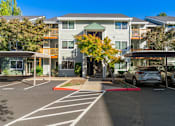 Thumbnail 3 of 66 - A parking lot with cars and apartment buildings in the background.