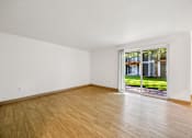 Thumbnail 2 of 37 - A room with a wooden floor and a sliding glass door.