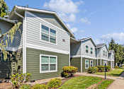 Thumbnail 66 of 74 - A row of houses with green and grey siding.