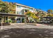 Thumbnail 2 of 66 - A parking lot with cars and apartment buildings in the background.