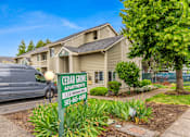 Thumbnail 1 of 36 - A sign for Cedar Grove Apartments is in front of a building.