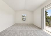 Thumbnail 36 of 74 - A room with a carpeted floor and a window showing a view of trees.