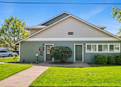 Thumbnail 3 of 35 - A house with a grey front and a green door.
