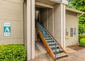 Thumbnail 3 of 36 - A staircase with a blue railing leads to a doorway with a sign that reads 212 A 112.