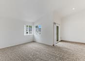 Thumbnail 4 of 36 - A room with a carpeted floor and a window overlooking a street.