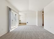 Thumbnail 38 of 74 - A spacious room with a carpeted floor and a door on the right side.