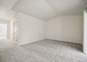 Thumbnail 7 of 74 - A large empty room with carpeted floor and white walls.