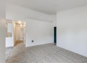 Thumbnail 8 of 36 - A large empty room with a carpeted floor and white walls.