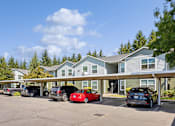 Thumbnail 70 of 74 - A parking lot with cars and a building in the background.