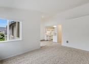 Thumbnail 9 of 36 - A spacious, empty room with a window and a door leading to another room.
