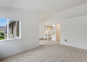 Thumbnail 7 of 36 - A large empty room with a window and a door leading to another room.