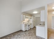 Thumbnail 8 of 36 - A kitchen with white appliances and a tiled floor.
