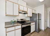 Thumbnail 42 of 74 - A kitchen with a stove top oven and a refrigerator.