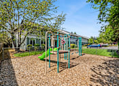 Thumbnail 9 of 35 - A playground with a green slide and a red slide.