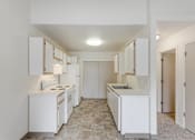 Thumbnail 11 of 36 - A kitchen with white appliances and cabinets.