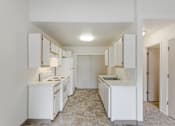 Thumbnail 9 of 36 - A kitchen with white appliances and cabinets.
