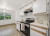 Thumbnail 19 of 37 - A kitchen with white cabinets and a black stove top oven.