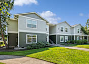 Thumbnail 73 of 74 - A row of houses with green lawns in front.
