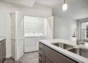 Thumbnail 16 of 46 - A modern kitchen with a stainless steel sink and white appliances.