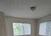 Thumbnail 6 of 17 - A room with a carpeted floor and a window with blinds.