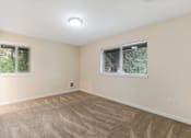 Thumbnail 44 of 66 - A room with a carpeted floor and two windows.