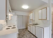 Thumbnail 12 of 36 - A kitchen with white appliances and cabinets.