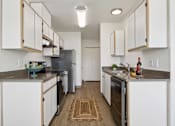 Thumbnail 44 of 74 - A kitchen with white cabinets and a grey counter top.