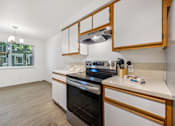 Thumbnail 6 of 37 - A modern kitchen with a stove top oven and a microwave.