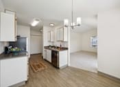 Thumbnail 45 of 74 - A kitchen with white cabinets and a wooden floor.