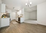 Thumbnail 11 of 74 - A kitchen with white cabinets and a wooden floor.