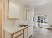 Thumbnail 12 of 36 - A kitchen with white countertops and wooden cabinets.