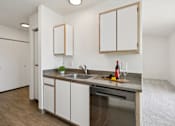 Thumbnail 46 of 74 - A kitchen with a stainless steel dishwasher and white cabinets.