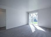 Thumbnail 29 of 34 - A room with a carpeted floor and a door leading outside.